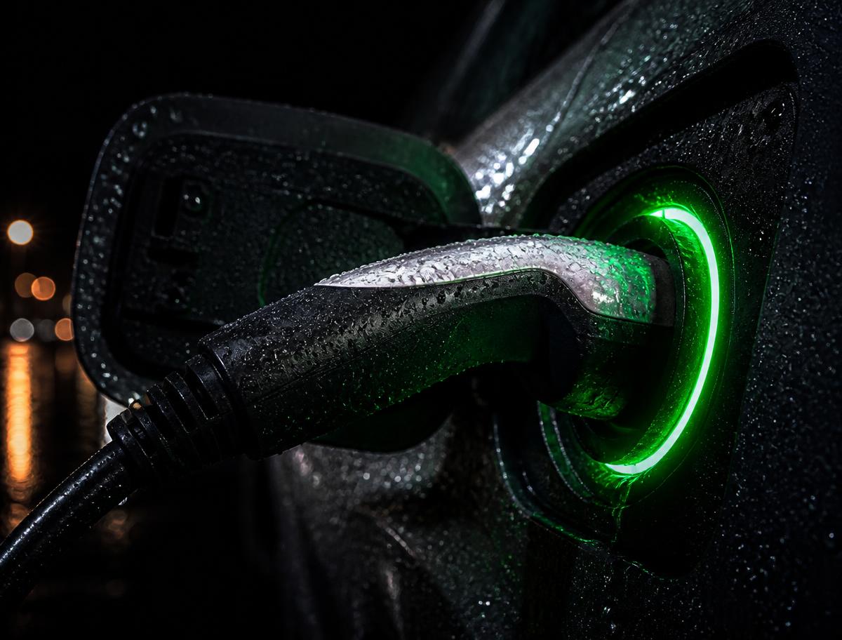 Conector de recarga plugado em carro elétrico com anel de luz verde